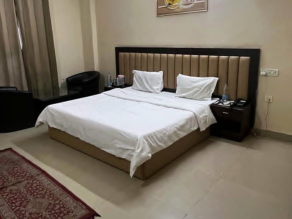 Deluxe room — queen bed with fresh white linen